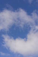 an azure blue sky with three white clouds