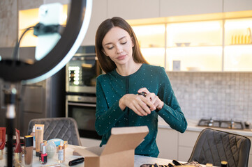 Pretty young womam demonstrating samples of new cosmetics