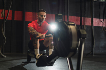 Fototapeta na wymiar Chico musculoso con camiseta roja practicando deporte en un gym