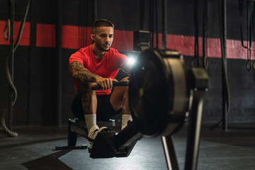 Obraz na płótnie Canvas Chico musculoso con camiseta roja practicando deporte en un gym
