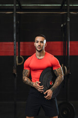 Fototapeta na wymiar Chico musculoso con camiseta roja practicando deporte en un gym