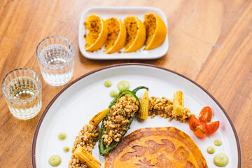 Chile relleno de escamoles con elotes y jitomates 