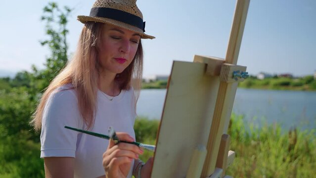 Woman artist painting countryside landscape