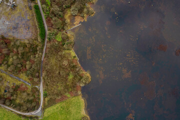 Aerial top down view on a small country road by a lake.