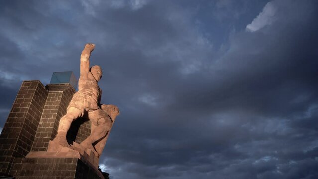 Statue of a Mexican warrior rising his hand at night in Guanajuato, Mexico