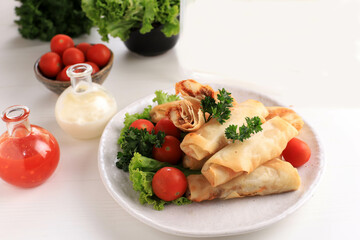 Deep Fried Spring Rolls, Popular as Lumpia or Popia. Served on White  Plate, White table with Spicy Sauce and Mayonaise. Copy Space for Text