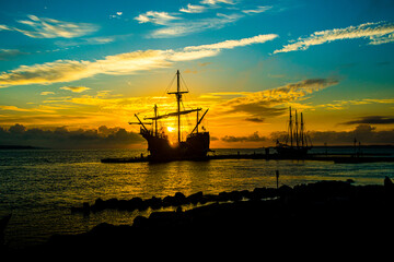 Spanish galleon docked in the bay at sunrise - obrazy, fototapety, plakaty