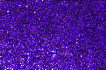 Fabric texture sparkling abstract background in Pantone 2022 Veri Peri color with sequins and metallic sheen. festive sparkling textiles with sequins. Very peri fabric with fish scale sequins