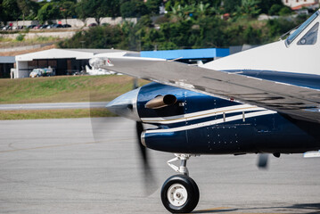 Detalhe de um avi&atilde;o monomotor com a h&eacute;lice girando