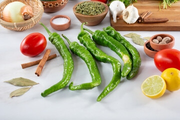 A view of a row of several green Italian long hot chili peppers.