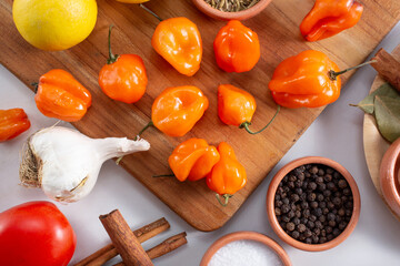 A top down view of several habanero chiles, among other salsa ingredients.