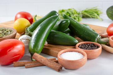 A view of a stack of jalapeño chiles, among other salsa ingredients.