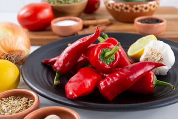 A top down view of a pile of red Fresno chiles, among other salsa ingredients.