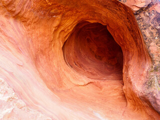 A small wind-formed hole in a vertical red sandstone face