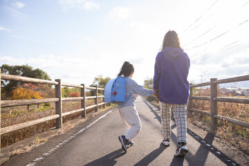 夕日に向かって歩く親子　Parent and child