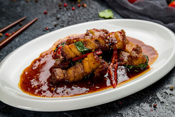 Pork in chili sauce with rice Chinese cuisine on dark stone table macro close up