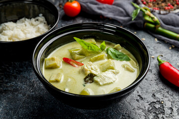 green Chinese soup on black bowl on dark stone table