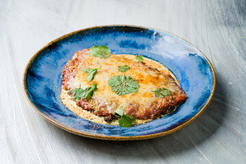 Vienna schnitzel from veal in sauce on grey table