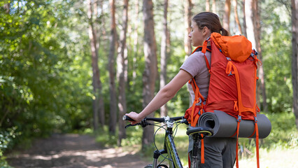 Obraz premium Caucasian woman rides a bicycle in the forest