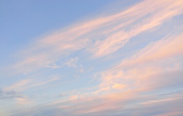 Clear blue sky with glowing pink cirrus and cumulus clouds after storm at sunset. Dramatic...