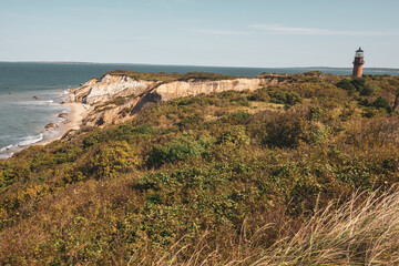 Gayhead lighthouse in Martha's Vineyard New England during sunny day on cliffside near ocean