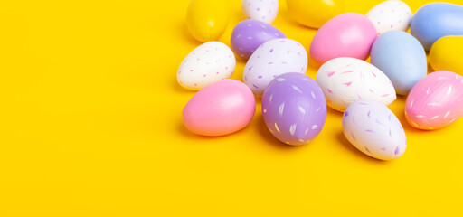Multicolored easter eggs on yellow background. Easter concept. Top view. Copy space