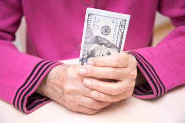 The hands of an elderly woman with dollars close-up. Concept having a financial strategy. - 482978378