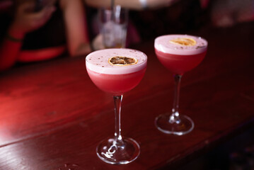 Two red cocktails with orange in a nightclub