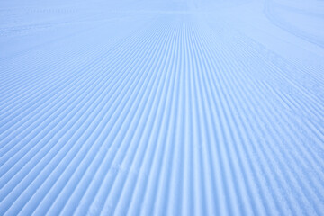 Fresh snowfall after the groomers have finished rolling the ski slopes, pattern and texture in a...