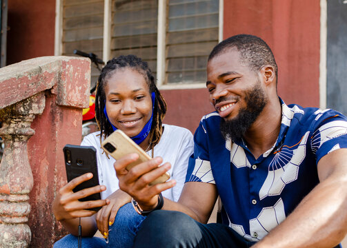 image of two young african male and female sharing mobile connection