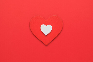 A big red and a small white heart on a red background. The concept of falling in love and Valentine's day. Minimalism.