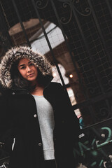 Brunette Girl in Black Coat and Fur Hood Model Shots Against Metal Gate