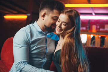 Fototapeta premium Young couple flirting at their first date at the restaurant. Valentine's Day. First kiss.