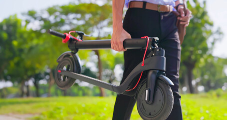 man walks with electric scooter