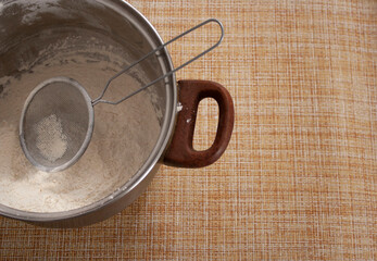 Flour sieve pan on light brown tablecloth homemade baking bread dough cakes