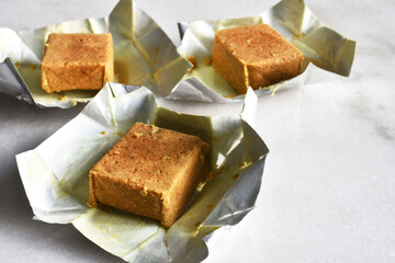 A close up image of three chicken flavored bouillon cubes used for cooking. 