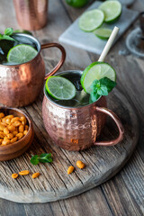 Moscow Mule cocktails garnished with mint leaves and lime wedges.