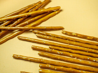 Salted sticks. Confectionery on the table. Salty baked goods. Snack for beer. Dough product on a beige background.