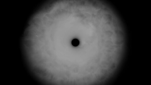 Fluffy white smoke comes out of a round black hole in the center of the screen. Abstract pattern of the iris.