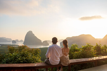 Happy couple traveler enjoy Phang Nga bay view point, Tourists relaxing at Samet Nang She, near Phuket in Southern Thailand. Southeast Asia travel, trip, love, together and summer vacation concept - obrazy, fototapety, plakaty
