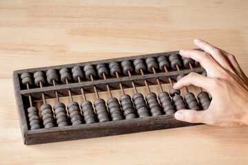 Vintage tone of Man's hands accounting with old abacus and hold electronic calculator. picture financial concept design.