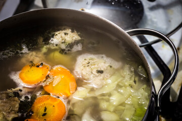 The soup is cooked on the stove during cooking in a large saucepan.