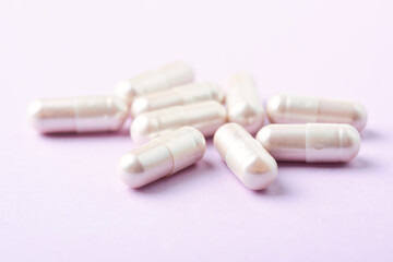 Carnitine capsules. Concept for a healthy dietary supplementation. Bright paper background. Soft focus. Close up.