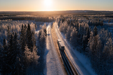 Cargo truck on a highway in winter landscape against sunset. Delivery and transportation in northern europe. - 482998953