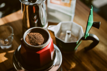 Finely ground coffee and vintage coffee maker moka pot on wooden table at home ,Selective focus.