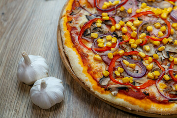 pizza with prosciutto, onion, red pepper, corn, tomato sauce, mushroom and cheese
