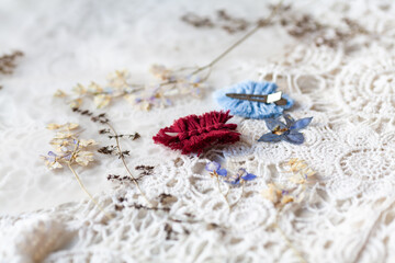 Hairpin in the form of a leaf in macrame technique against the background of dry foliage and lace