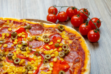 pizza with ham, mushroom, corn, green olives, red pepper and chesse