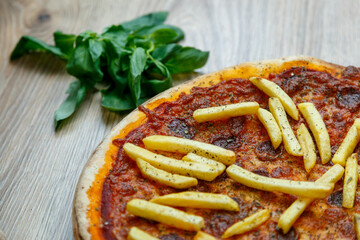 pizza with hot sausage and french fries on tomato sauce