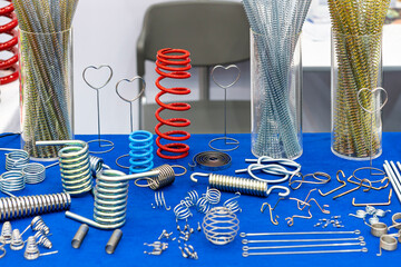 various type metal spring such as extension compressing torsion clip constant force and etc. and wire bending many shape parts for machine or other on table